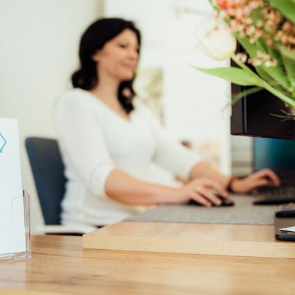 Junge Frau sitz am Pc im Büro